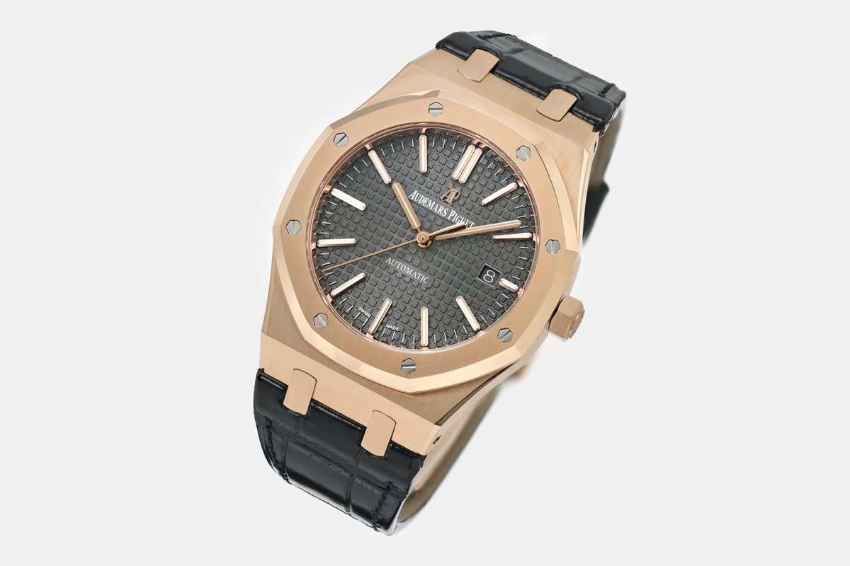 Three-quarter view of the rose-gold case and octagonal bezel with the black Tapisserie dial at an angle, the crown at the right and the black leather strap curving away beneath the case