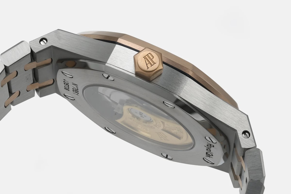 Case back detail through the glass, with the winding weight visible inside and the bracelet links running away from the lugs