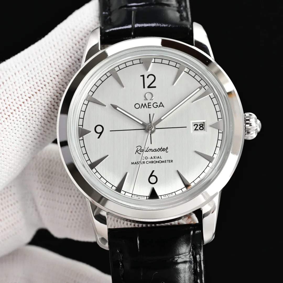 Brushed pale grey dial straight on with applied numerals at twelve, nine and six, baton markers between them, the date at three and a black stitched leather strap below the steel case