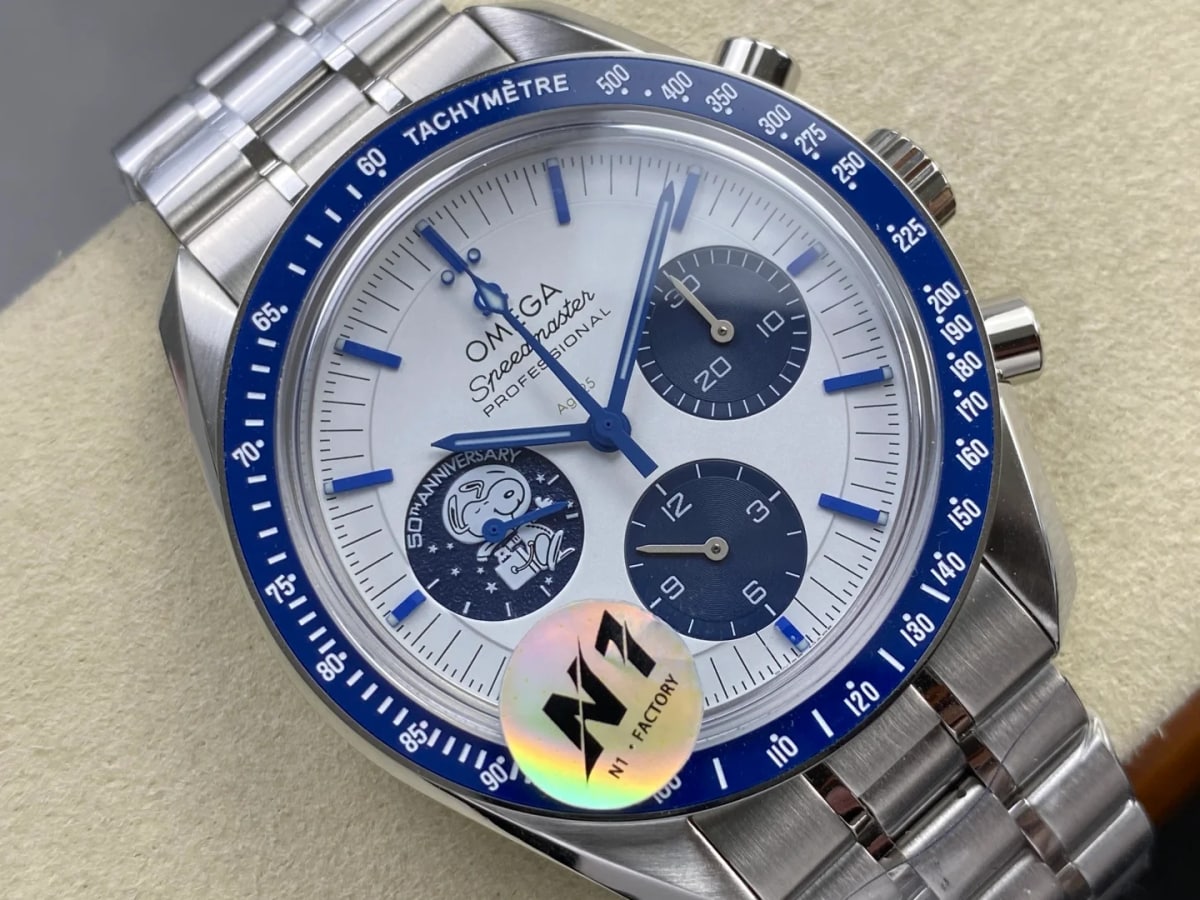 Angled view of the dial and its three blue registers, the ring of lettering around the medallion, the tilted bezel scale and the bracelet below the case