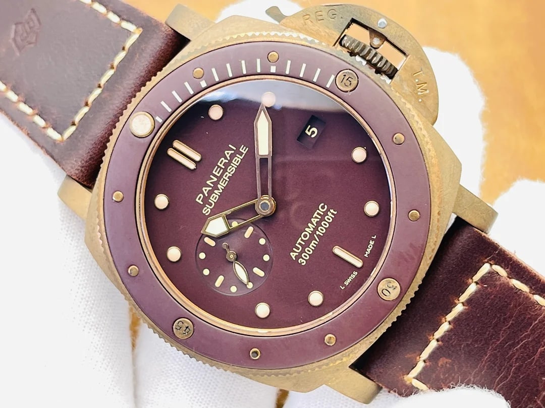 Close-up detail of the brown dial and the bezel scale, with the printed brand name and line name above the centre, the small-seconds register at nine o'clock and the bezel's raised graduations across the top of the frame