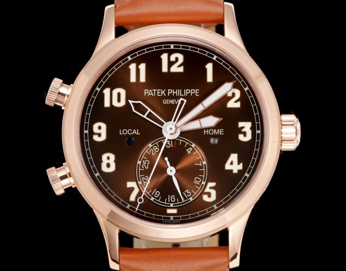 Close-up of the brown dial showing the maker and city lettering above the centre, LOCAL to the left and HOME to the right, the applied Arabic numerals and the printed minute track