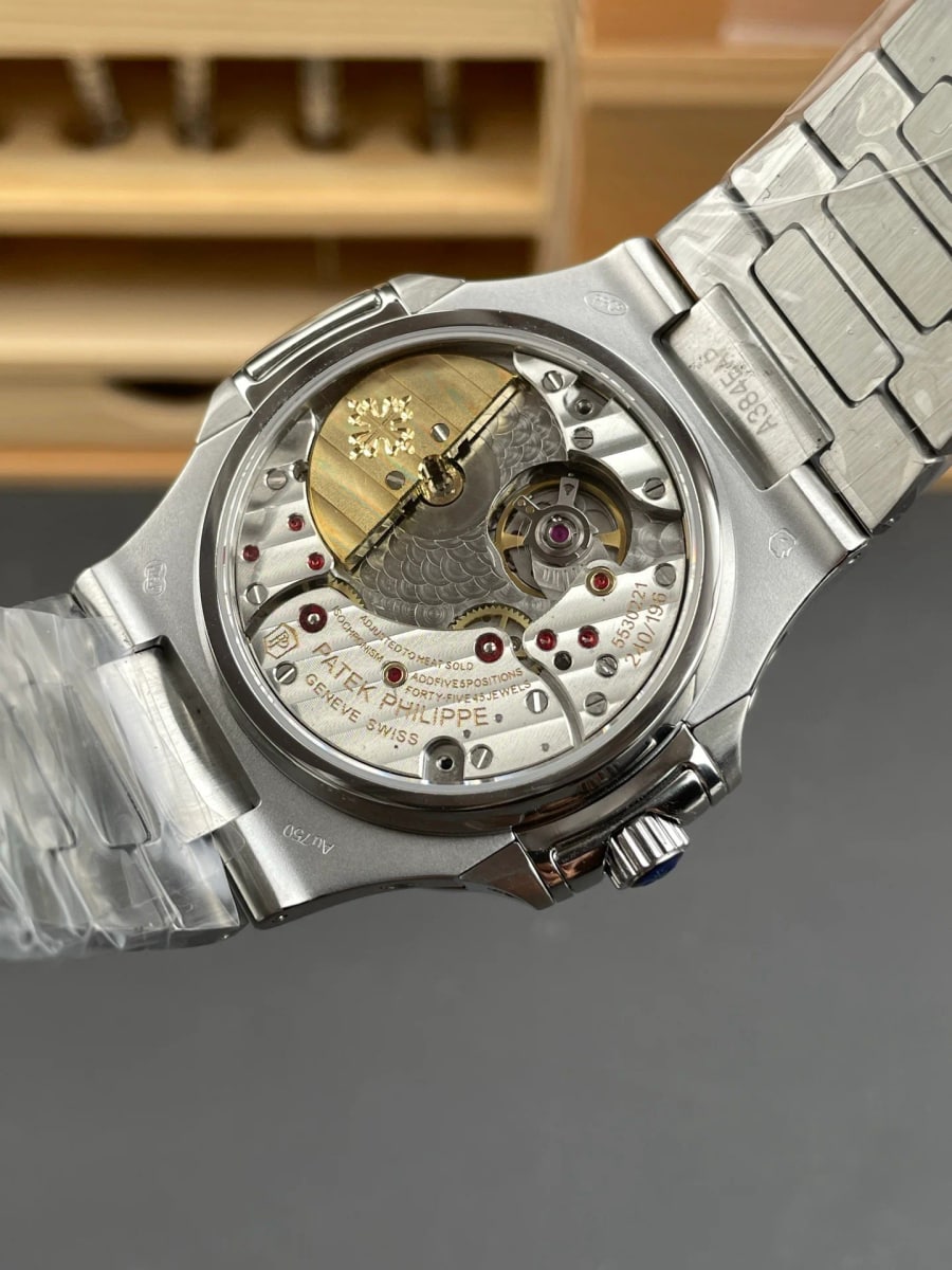 Case back detail through the crystal, with the winding segment off centre above the plates, engraving around the outer ring and the bracelet attached at the lugs