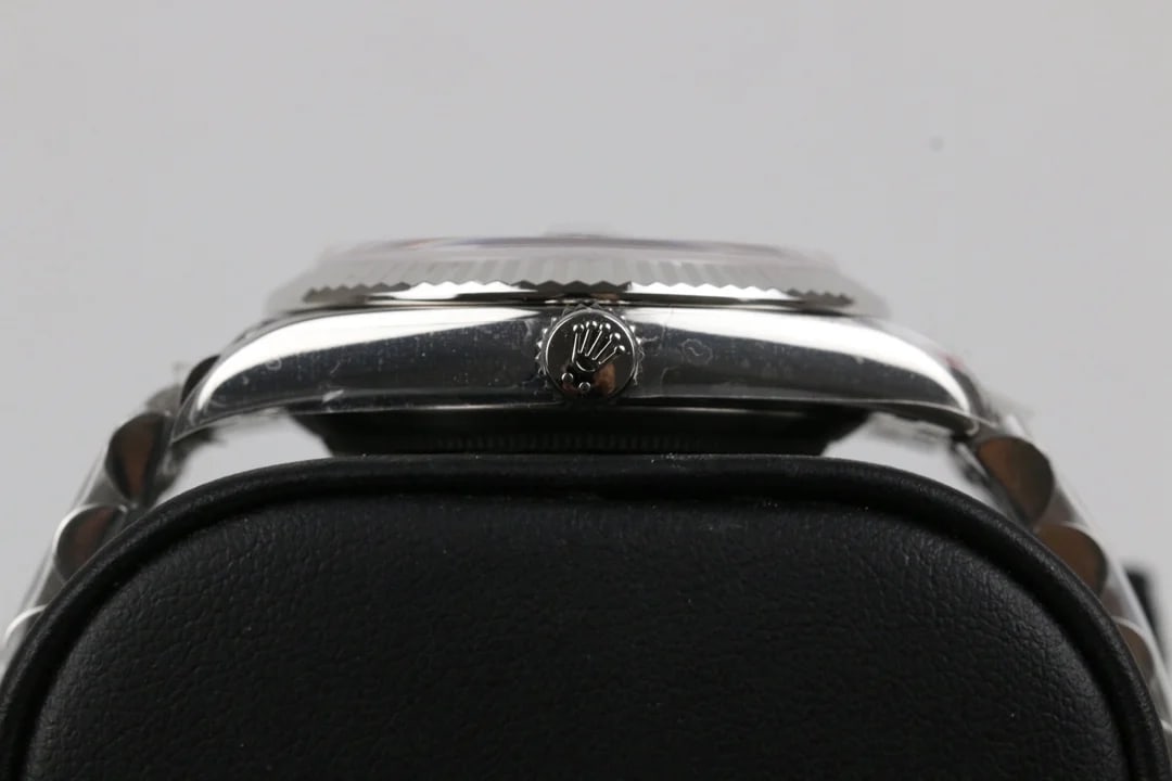 Bezel and crown detail photographed across the case, showing the fluted ring, the polished case flank and the winding crown between the lugs
