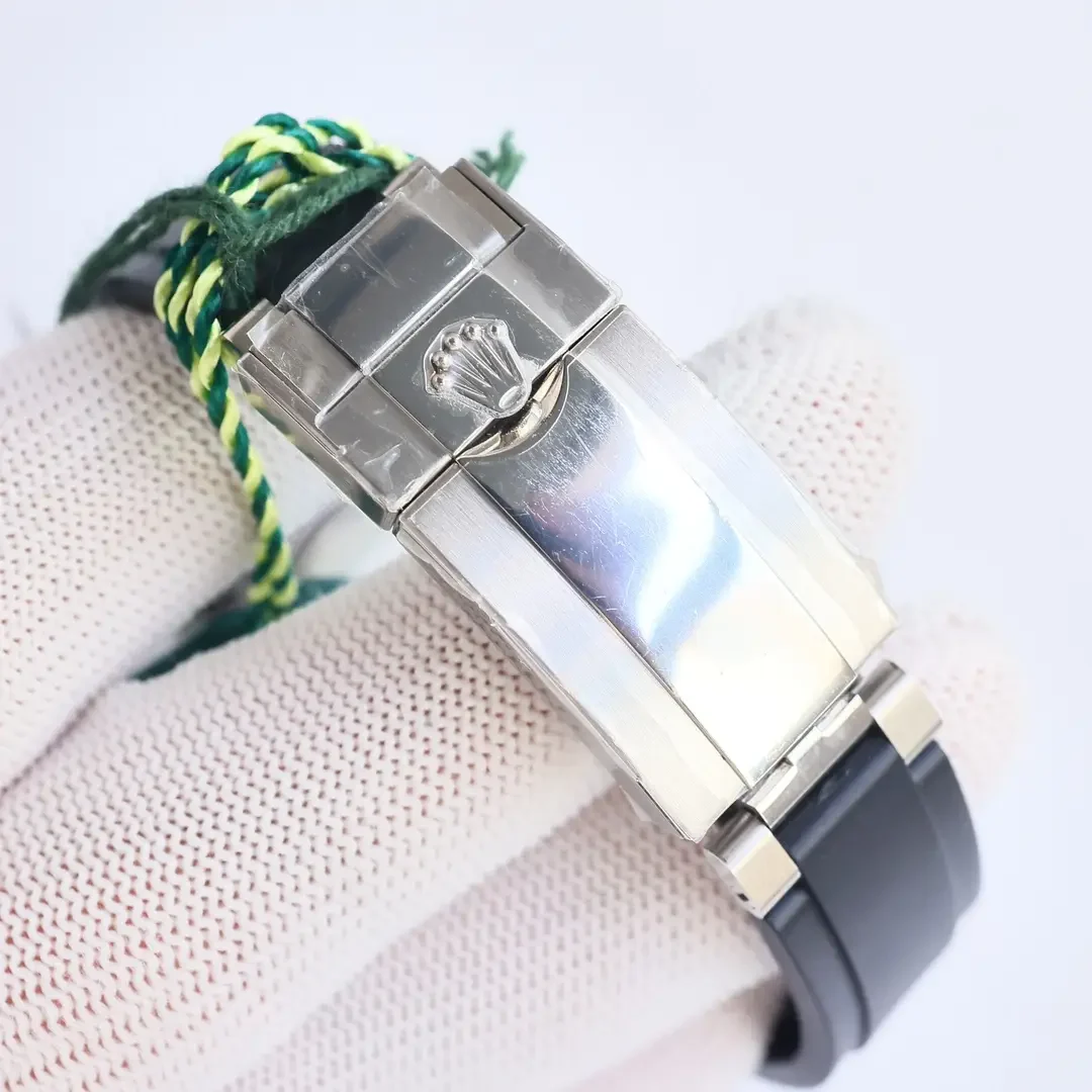 Clasp detail photographed from below with the folding blade closed across the rubber strap and the cord tag still attached