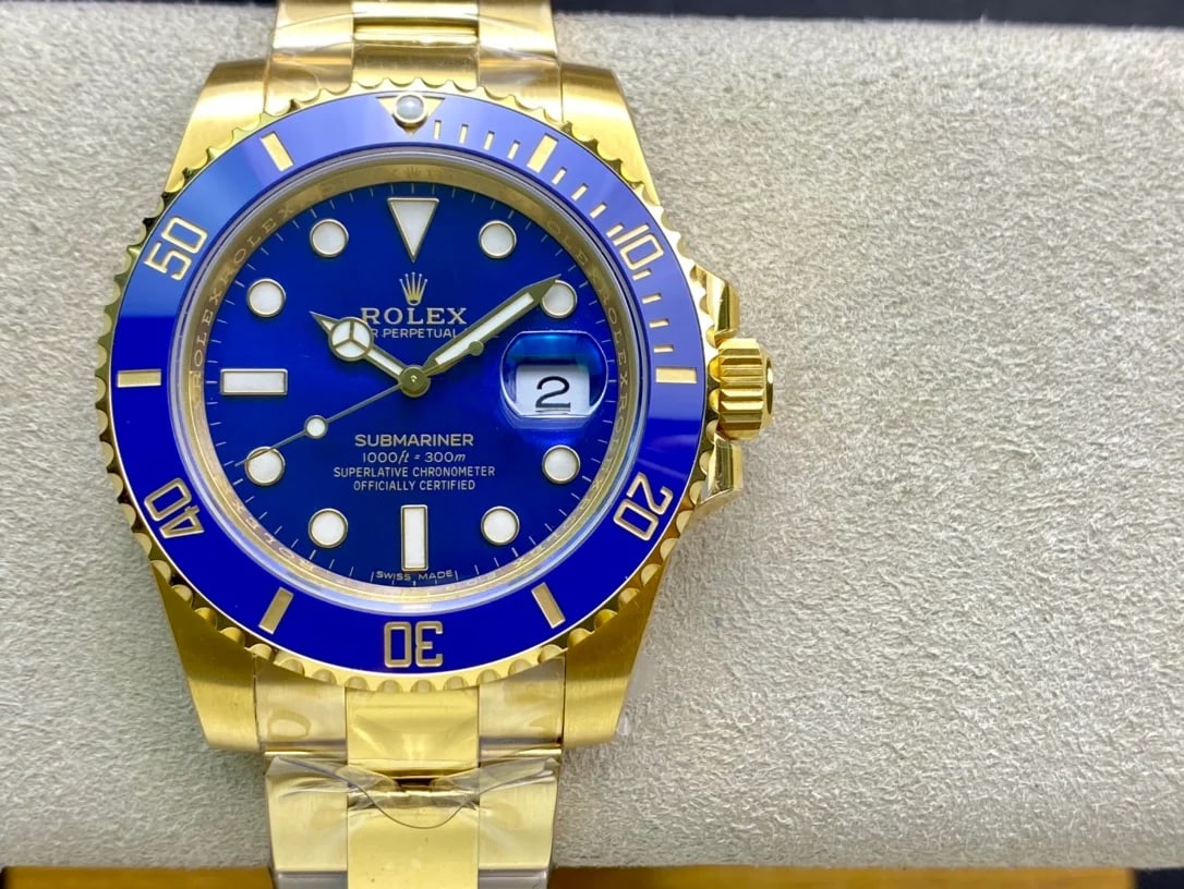 Blue dial straight on in the yellow-gold case, with the blue bezel insert and its gold-numeral sixty-minute scale, the date under its magnifier and the three-link gold bracelet