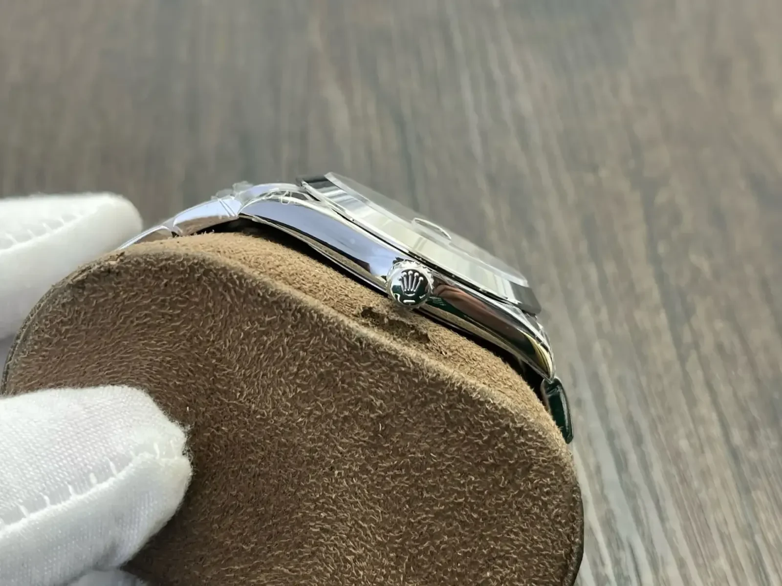 Case side close-up with the winding crown, the polished case flank and the bracelet end link where it meets the lugs