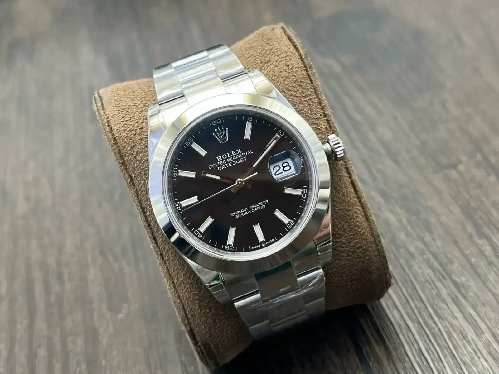 Three-quarter view showing the smooth bezel above the black dial and the three-link bracelet with its polished centre links