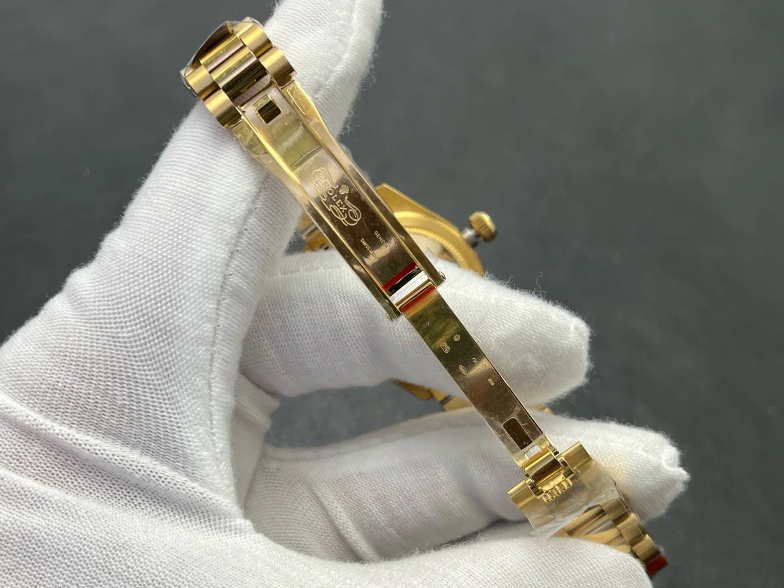 Bracelet clasp detail showing the three-piece links and the clasp folded flush with the bracelet, with the protective wrap still in place