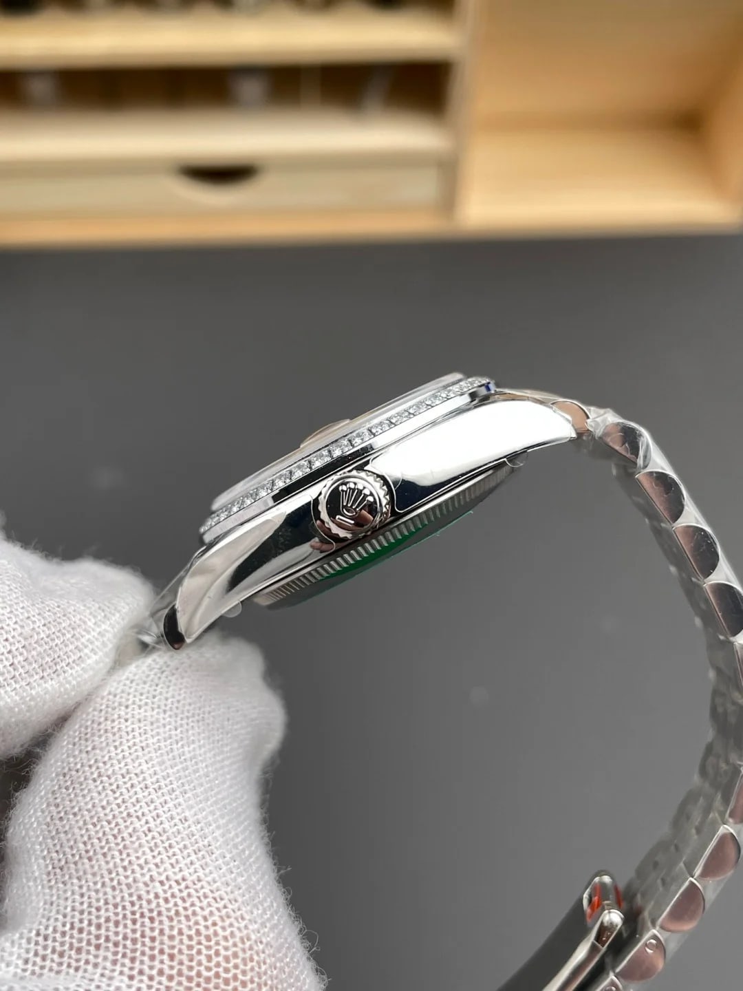 Case and bracelet in profile from the side, showing the height of the stone-set bezel above the case and the crown between the end links
