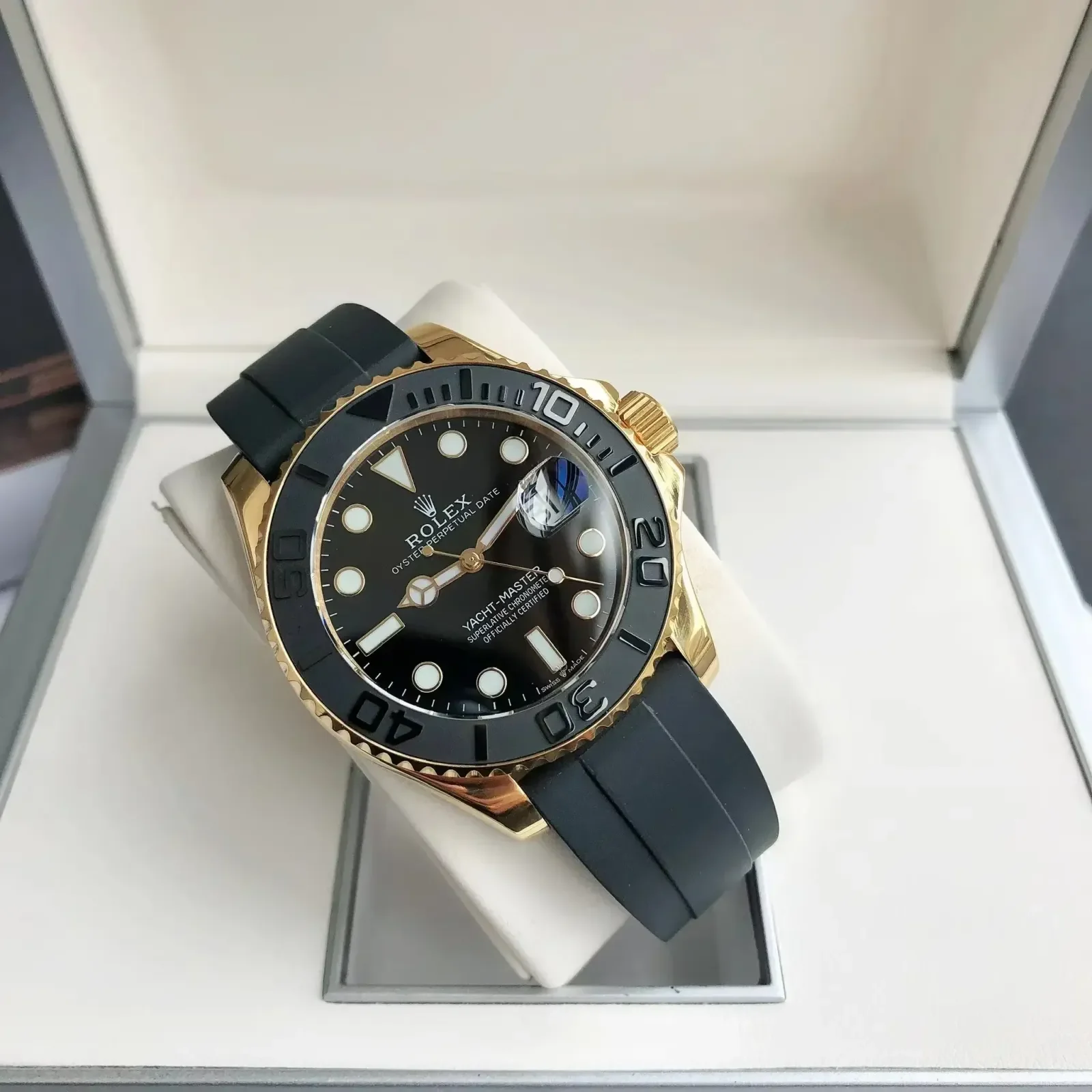 Three-quarter view of the watch resting in its presentation box, showing the bezel above the case flank and the curve of the black strap