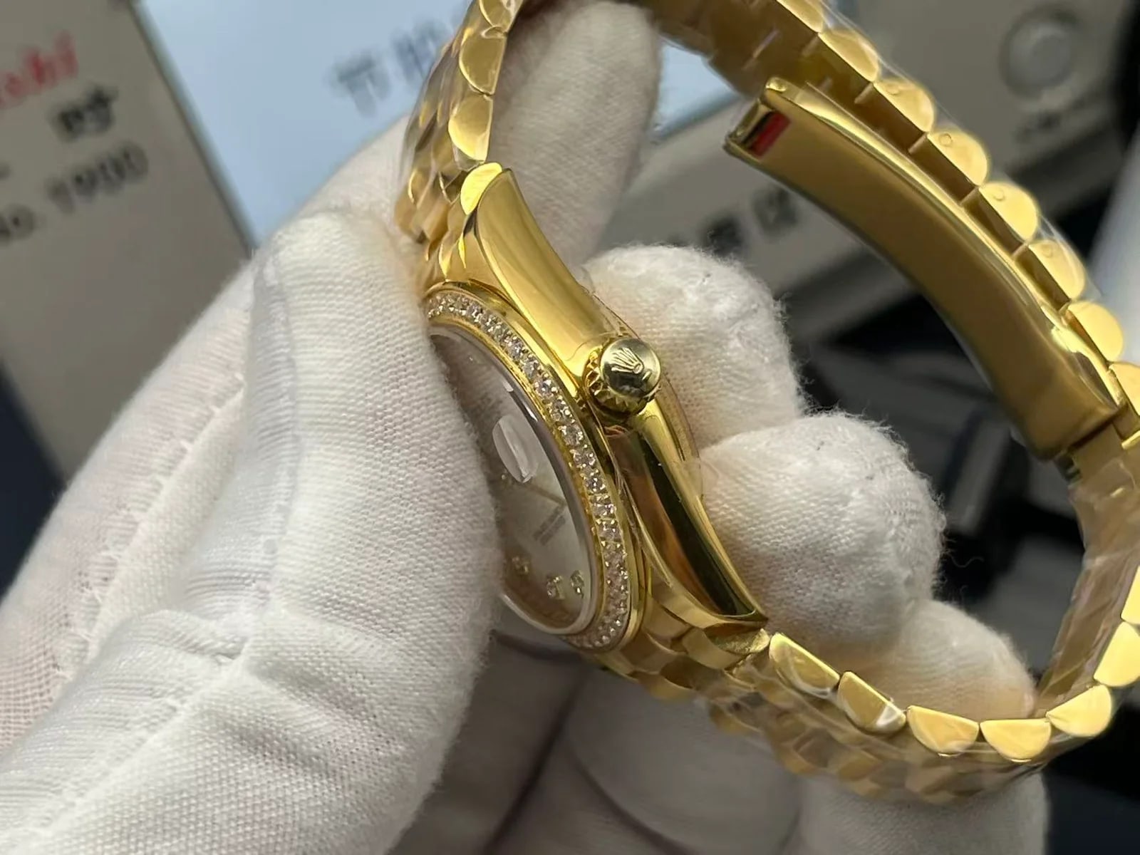 Case side close-up with the winding crown, the edge of the stone-set bezel and the end links of the bracelet around the case