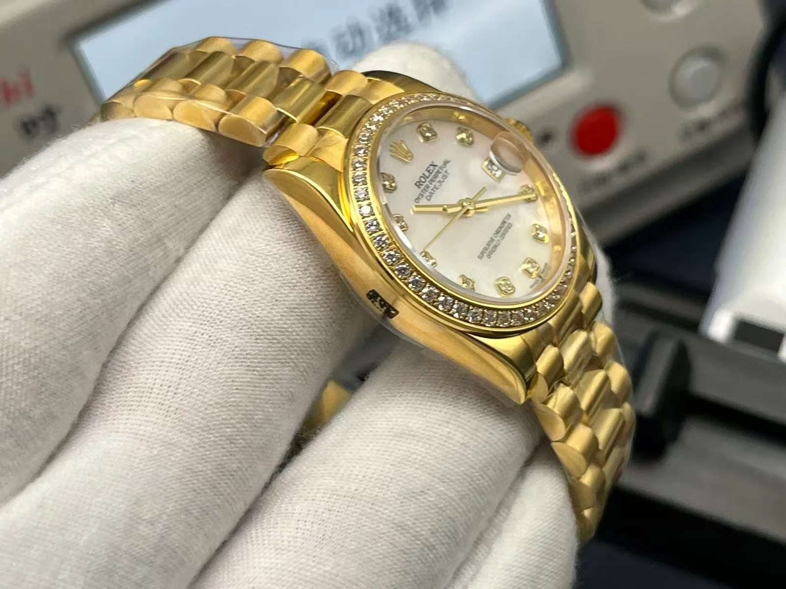 Dial close-up with the mother-of-pearl surface, its stone markers and the stone-set bezel in the foreground, showing the pattern across the material