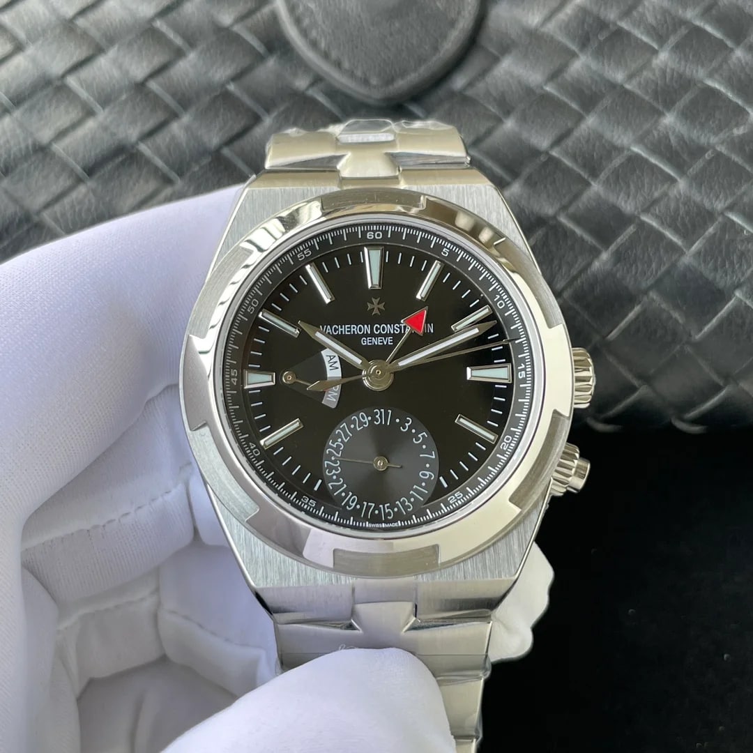 Black sunburst dial straight on in a steel case, with the brand lettering and cross above the centre, a red-tipped hand across the upper half, a small date counter above six o’clock and a steel bracelet below
