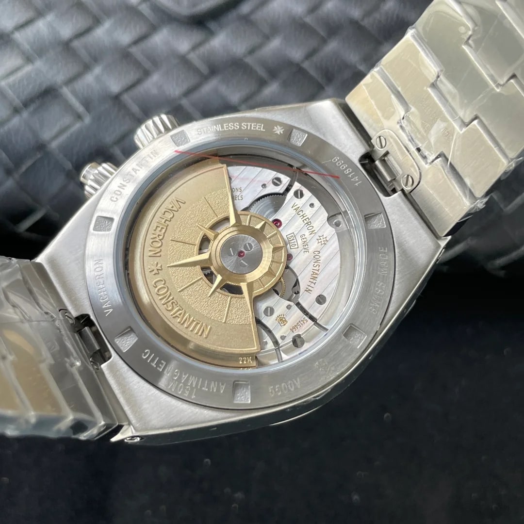 Case back detail with the sapphire window over the winding weight, engraved lettering around the rim and the bracelet links meeting the lugs on either side